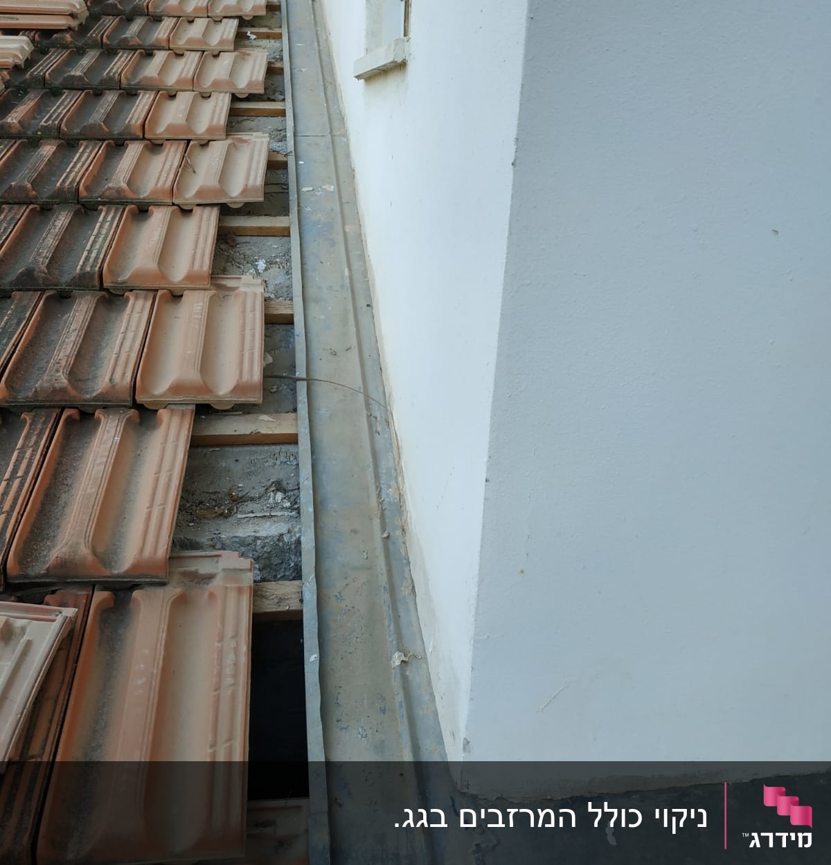 רעפים על גג ליד קיר לבן עם פח